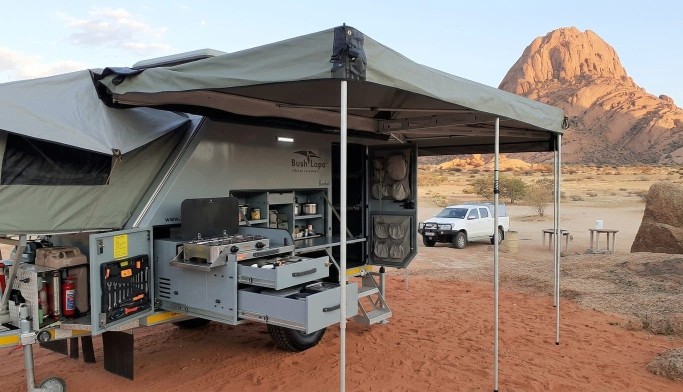 Bush Lapa trailer set up at camp, awning and kitchen open, Spitzkoppe in the background
